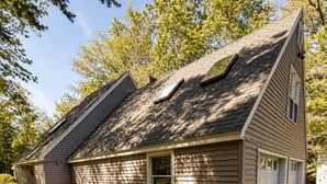 A two-story house with a sloped roof, a front porch, and a driveway. - Acadia Coastal Cape 20 min to Acadia National Park (Lamoine)