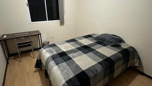 Une chambre à coucher avec un lit, un bureau et une fenêtre.