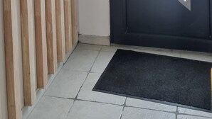 En dörr med en halvcirkelformad, frostad glaspanel, en väggpanel av trä och en skylt med texten ”HEM” på väggen.