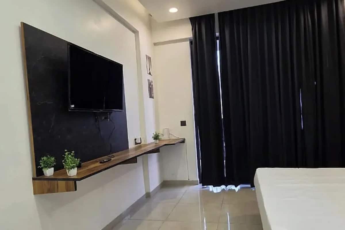 Ein modernes Schlafzimmer mit Flachbildfernseher, Deckenventilator und Bett.