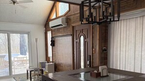 A spacious room with a large dining table, a ceiling fan, and a modern chandelier. - Poconos-Four Season Amenities-Game Room-Fire Pit-Hot Tub-Ski  (Bushkill)