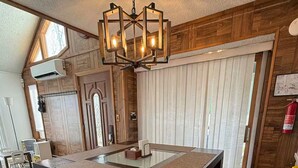A modern dining area with a large table, benches, and a unique chandelier. - Poconos-Four Season Amenities-Game Room-Fire Pit-Hot Tub-Ski  (Bushkill)