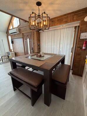 A modern dining area with a large table, benches, and a unique chandelier. - Cozy Mountain Escape-Poconos-Four Season Amenities-Game Room-Fire Pit-Hot Tub (Bushkill)