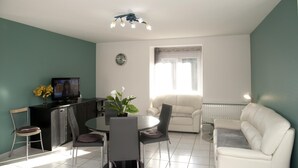 A modern living room with a dining area, a sofa, a TV, and a clock on the wall. - Les Hirondelles - NEBOUZAT (NEBOUZAT)