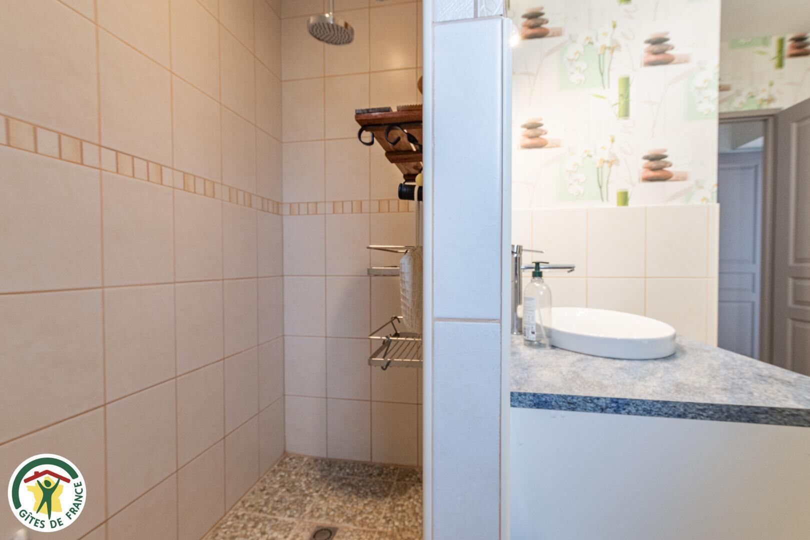 Ein Badezimmer mit Dusche, Waschbecken und Handtuchhalter.