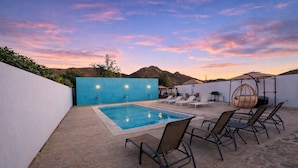 A rooftop pool area with a view of mountains, lounge chairs, and a hanging chair. - HOTEL LARIMAR - Valle de Guadalupe (Valle de Guadalupe)