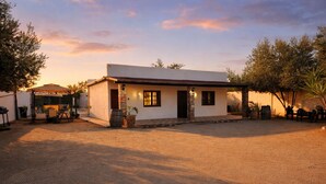 A single-story building with a patio area, a covered seating area, and a small outdoor kitchen. - HOTEL LARIMAR - Valle de Guadalupe (Valle de Guadalupe)