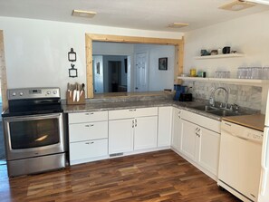 A kitchen with white cabinets, a stainless steel oven, and a dishwasher.