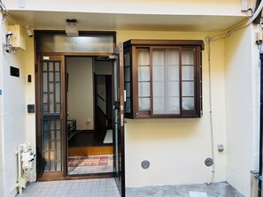 A narrow entrance with a wooden door and a small window. - Skytree Area Stay | Close to Asakusa & Disney (Sumida City)