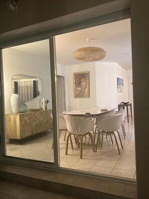 Ein Essbereich mit Tisch und Stühlen, einem Holzschrank und einem großen Spiegel.