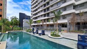 Un hôtel moderne doté d’une piscine, d’un espace extérieur aménagé et d’un jardin bien entretenu.