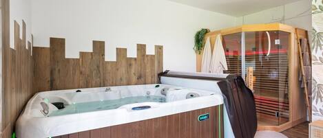Une salle de bain moderne avec un mur décoré en bois, une douche en verre et un logo bien visible sur la baignoire.