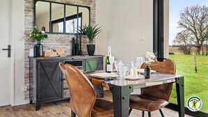 A dining area with a brick wall, a large mirror, and a view of the outdoors.