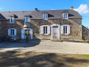 A stone building with a cobblestone driveway, a small balcony, and a door with a window above it. - Large, quiet "Un Air de Famille" country house with views of the Pyrenees (Mauvezin)