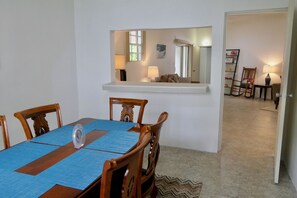 A dining area with a wooden table, chairs, and a blue placemat.