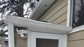 A white door with a glass panel, a mailbox, and a security camera on the exterior wall of a house. - Cute Southside Private Apartment in Bozeman (Bozeman)