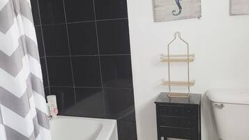 Une salle de bain avec une baignoire, des toilettes et un espace douche.