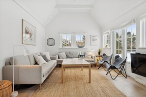 A modern living room with a sofa, a coffee table, and a TV. - Bright and spacious holidayhome near Vejby Strand (Vejby)