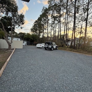 A gravel driveway leading to a parked white car and a black SUV. - Perfect 1-bedroom villa with AC in wonderful West Tampa near Tampa Bay Downs (Tampa)