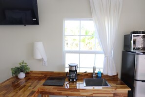 A kitchen with a wooden countertop, a coffee maker, a sink, a microwave, a refrigerator, a potted plant, and a window with curtains. - Perfect 1-bedroom villa with AC in wonderful West Tampa near Tampa Bay Downs (Tampa)
