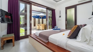 Ein Schlafzimmer mit einem großen Bett, einem Fernseher und Blick ins Freie.