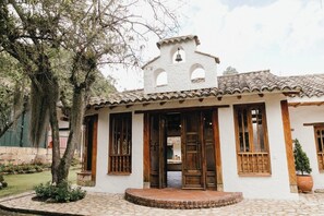 A traditional building with a bell tower, large wooden doors, and a tiled roof.