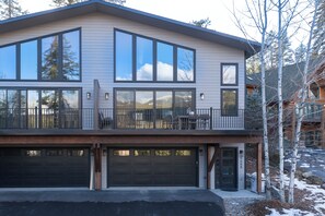 A modern two-story house with large windows, a balcony, and a garage. - Stunning Whitefish Retreat w/ Ski Views, Multiple Decks, Open Living & Near Glacier Adventures (Whitefish)