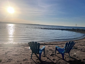Two blue chairs on a sandy beach with a view of the ocean and a distant shoreline. - Hawberry Haven - Waterfront, Private Sandy Beach on Mudge Bay, Kagawong (Kagawong)