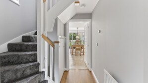 Un escalier menant à une salle à manger offrant une vue sur l’extérieur.