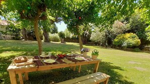 Ein Holztisch für ein Picknick mit Bänken, Tellern, Gläsern und Lebensmitteln.
