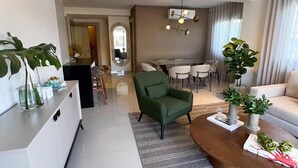 A modern living room with a green armchair, a coffee table, and a dining area in the background. - Quiet and cozy place (Santo Domingo)
