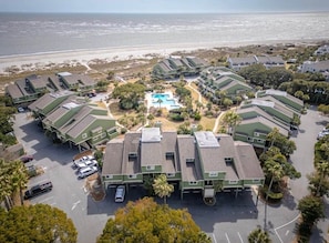 A coastal hotel with multiple green-roofed buildings, a central swimming pool, and a parking area. - New Listing! Mariners Walk 3F- Ocean View Balcony! (Isle of Palms)