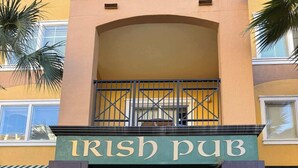 A building with a sign reading "Irish Pub" and doors labeled "Family" and "Dining." - Disney Resort Escape w/ Pirate Pool & Spa Sleep 6 (Orlando)