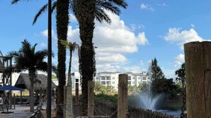 A serene outdoor area with palm trees, a wooden fence, and a water feature. - Disney Resort Escape w/ Pirate Pool & Spa Sleep 6 (Orlando)