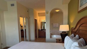 A hotel room with a large bed, a bathroom with a bathtub, and a kitchenette area. - Disney Resort Escape w/ Pirate Pool & Spa Sleep 6 (Orlando)