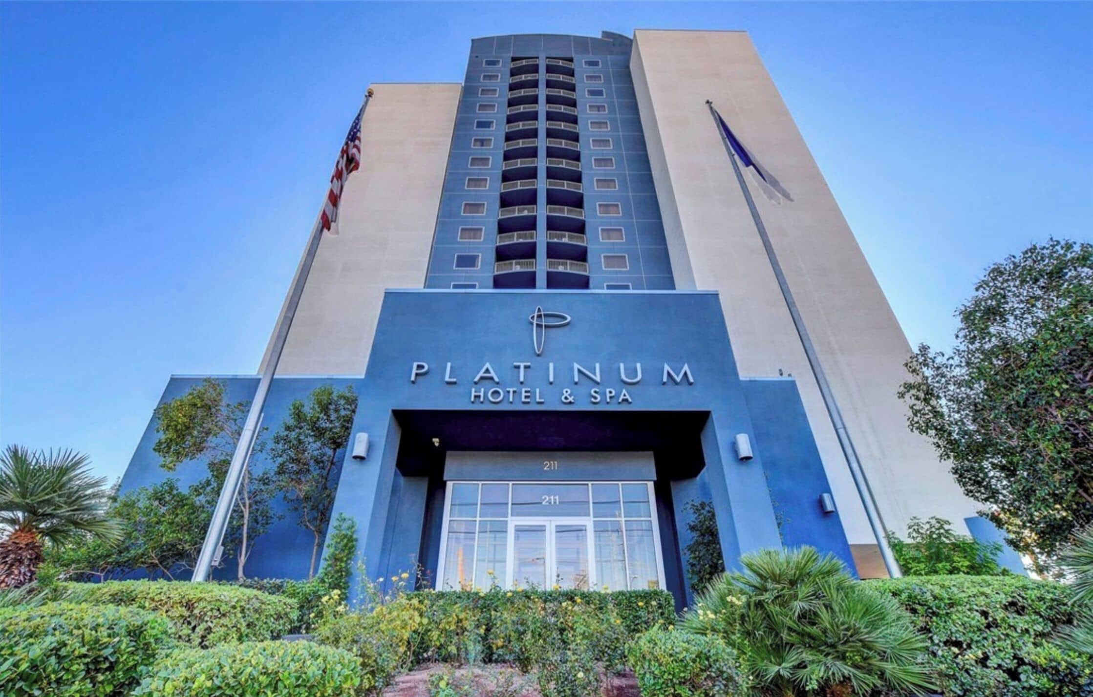 Ein hohes Gebäude mit einem Schild, auf dem 'Platinum Hotel & Spa' und die Nummer 211 steht.
