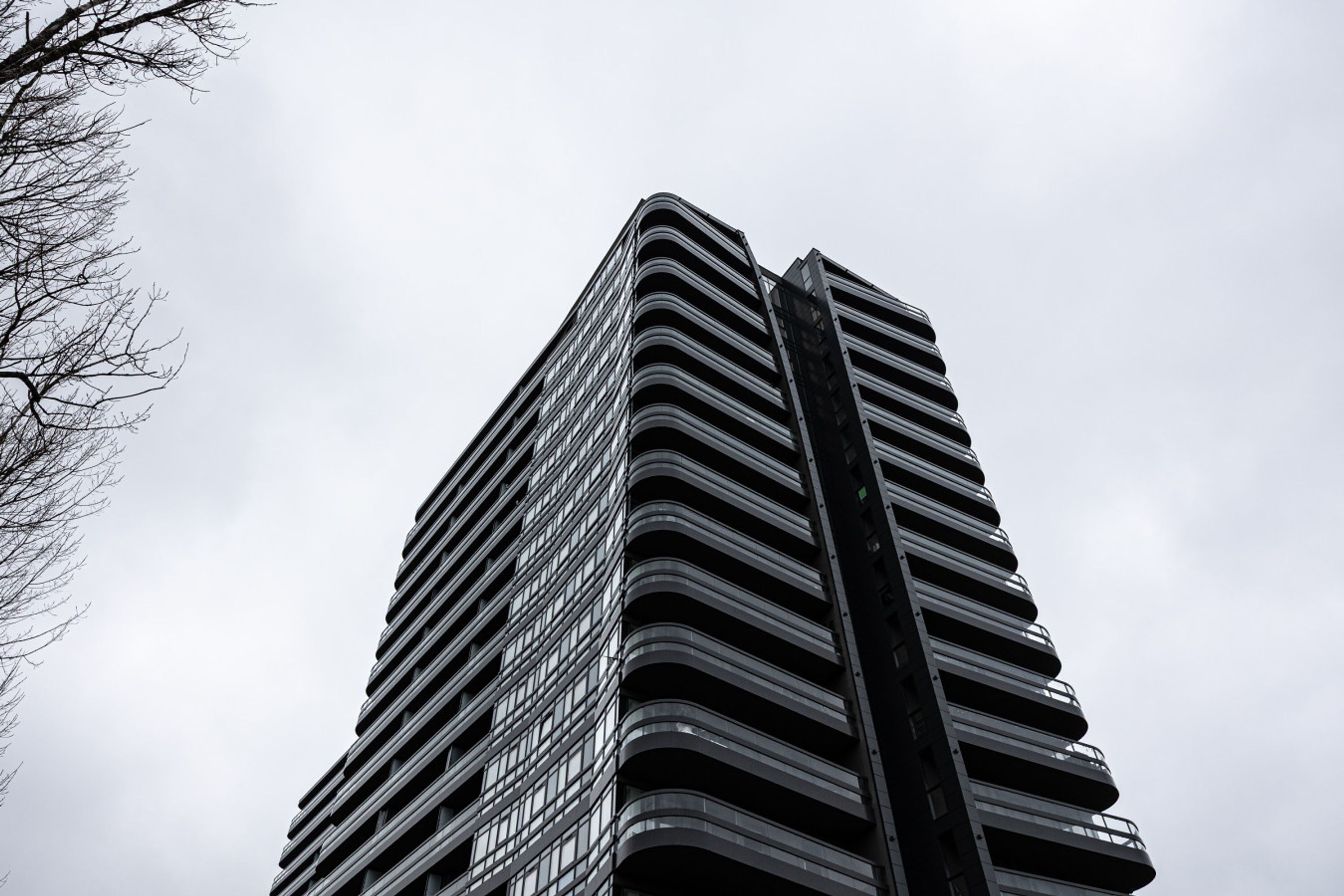 Een hoog, modern gebouw met een gebogen gevel en tal van ramen.