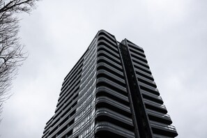 A tall, modern building with a curved facade and numerous windows.