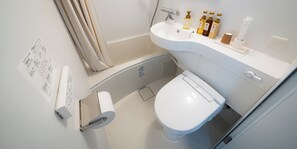 A small bathroom with a toilet, sink, and shower. There are toiletries on the sink counter. - R Hotel Namba East (Osaka)