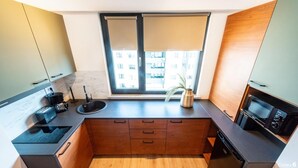 Eine moderne Küche mit Einbauofen, Spüle und Fenster mit Blick auf Gebäude.