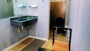 Een compacte, moderne badkamer met een wastafel, spiegel en toilet.