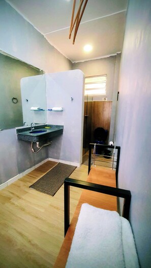 Ein kleines, modernes Badezimmer mit Waschbecken, Spiegel und Toilette.