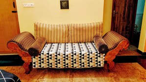 Ein Sofa mit einem geometrischen Musterbezug, eine Holztür und ein Holzboden.