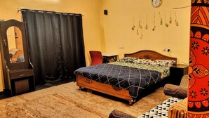 Ein Schlafzimmer mit einem Bett, einem Nachttisch, einem Spiegel, einem Vorhang und einer Wanduhr.