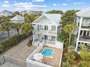A multi-story white building with a pool, surrounded by palm trees and other greenery. - 🏖️ Coastal Decor | Pool | Bikes | Ping-Pong Table 🏓 (Seagrove)