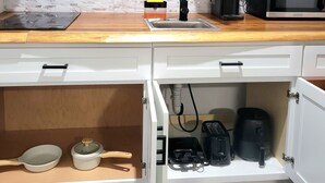 A kitchen with white cabinets, a wooden countertop, a sink, a microwave, and various appliances. - Private Suite Independent Entrance, All Amenities (Kissimmee)