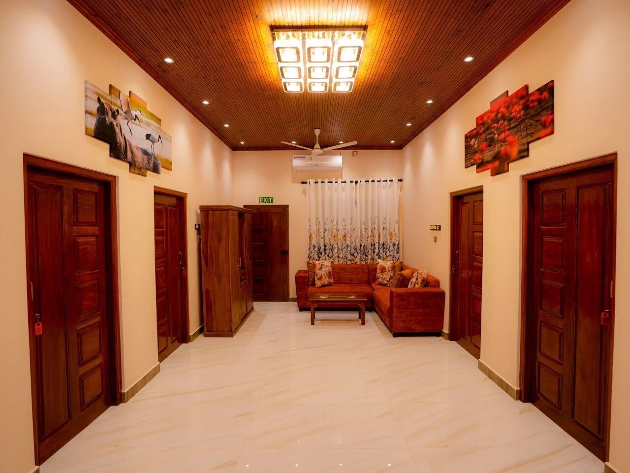 Un hall d’entrée spacieux, avec des portes en bois, un canapé et un luminaire au plafond.