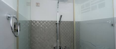 A glass-enclosed shower with a modern design, featuring a rain shower head and a handheld shower attachment.