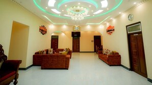 A spacious lobby with a chandelier, two sofas, and a clock on the wall. - Infenta's Villa (Pandatharippu)