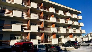 A multi-story building with balconies, labeled "Chesa Derby," featuring a modern architectural design with a combination of white and wooden elements. - Derby 31 by Interhome (St. Moritz)